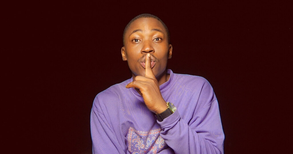 Image of a man making a a 'shush' gesture (symbolising taming your inner critic as a coach)