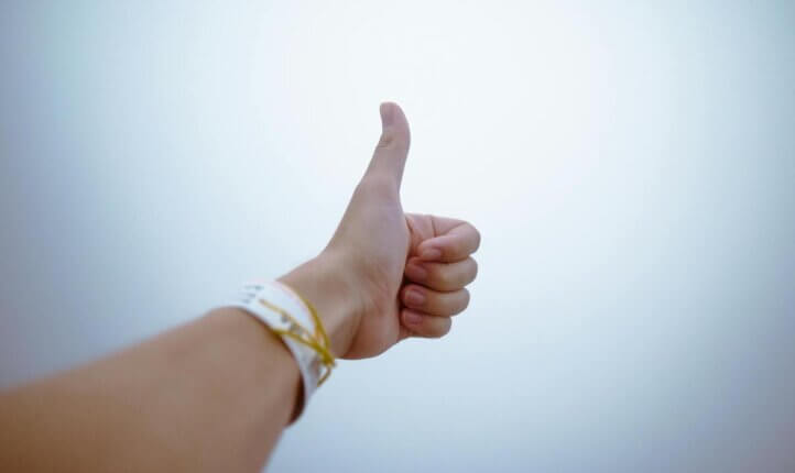 A thumbs up symbolising positive psychology and use of Ai in coaching.